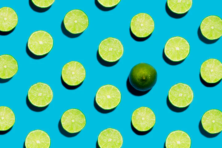 Sliced Open Geen Limes on Symmetrical Blue Background with one peeled open