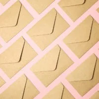 Kraft brown paper envelopes on pink background