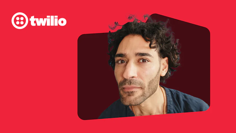A man with curly hair posing in front of a red background with Twilio logo.