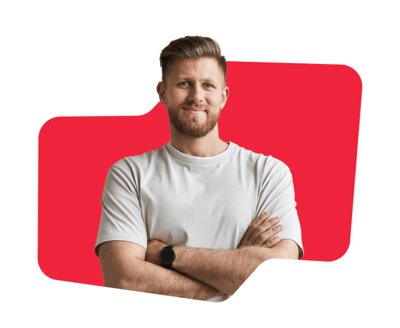 Smiling man with a beard, arms crossed, wearing a white t-shirt against a red abstract background.